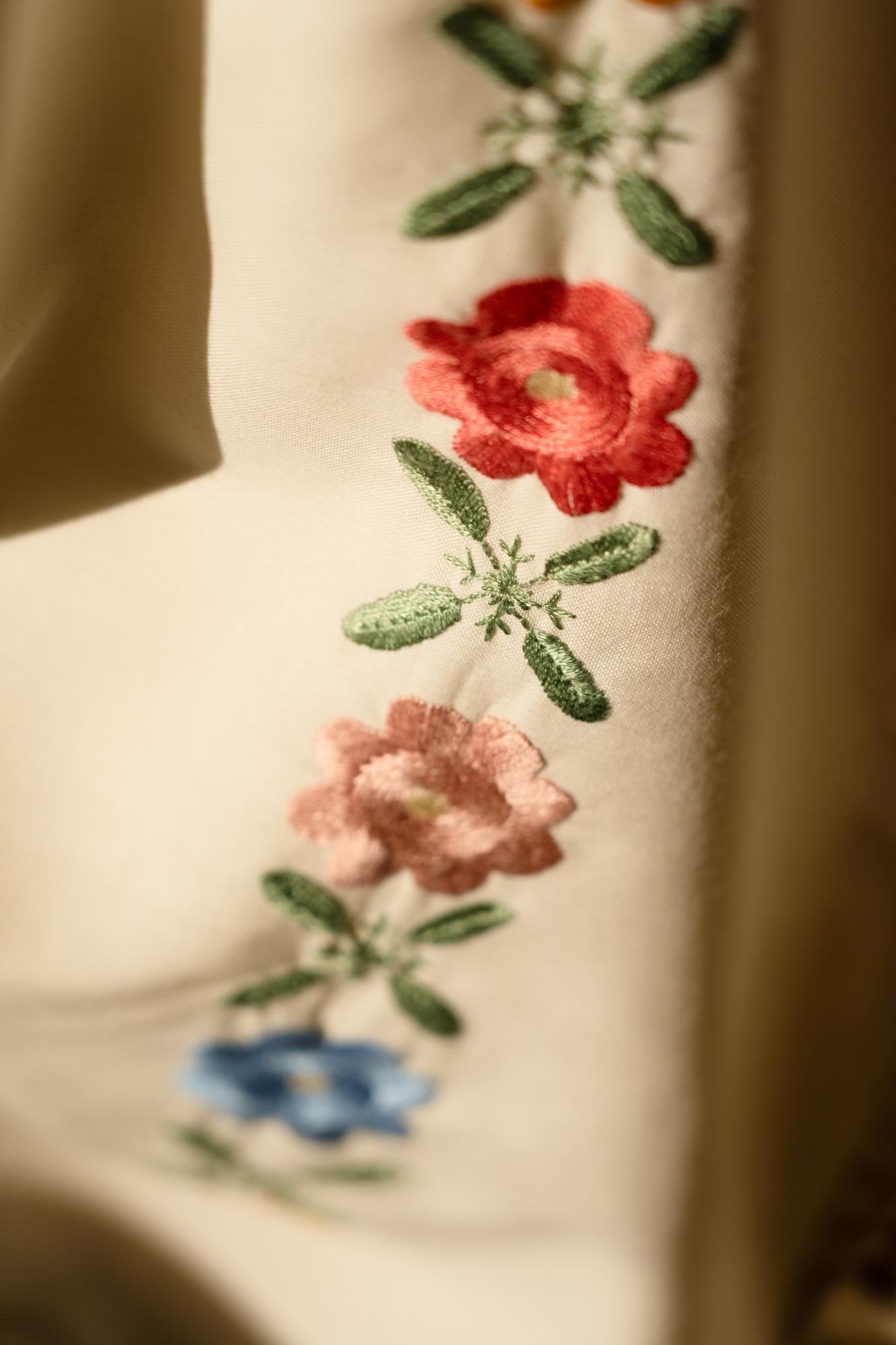 Nahaufnahme handgestickter Blüten auf Leinen
